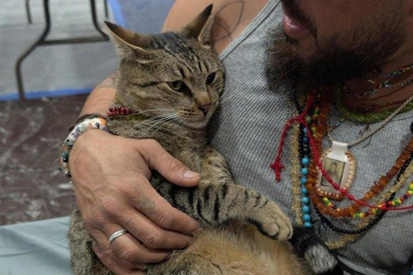 man snuggling cat